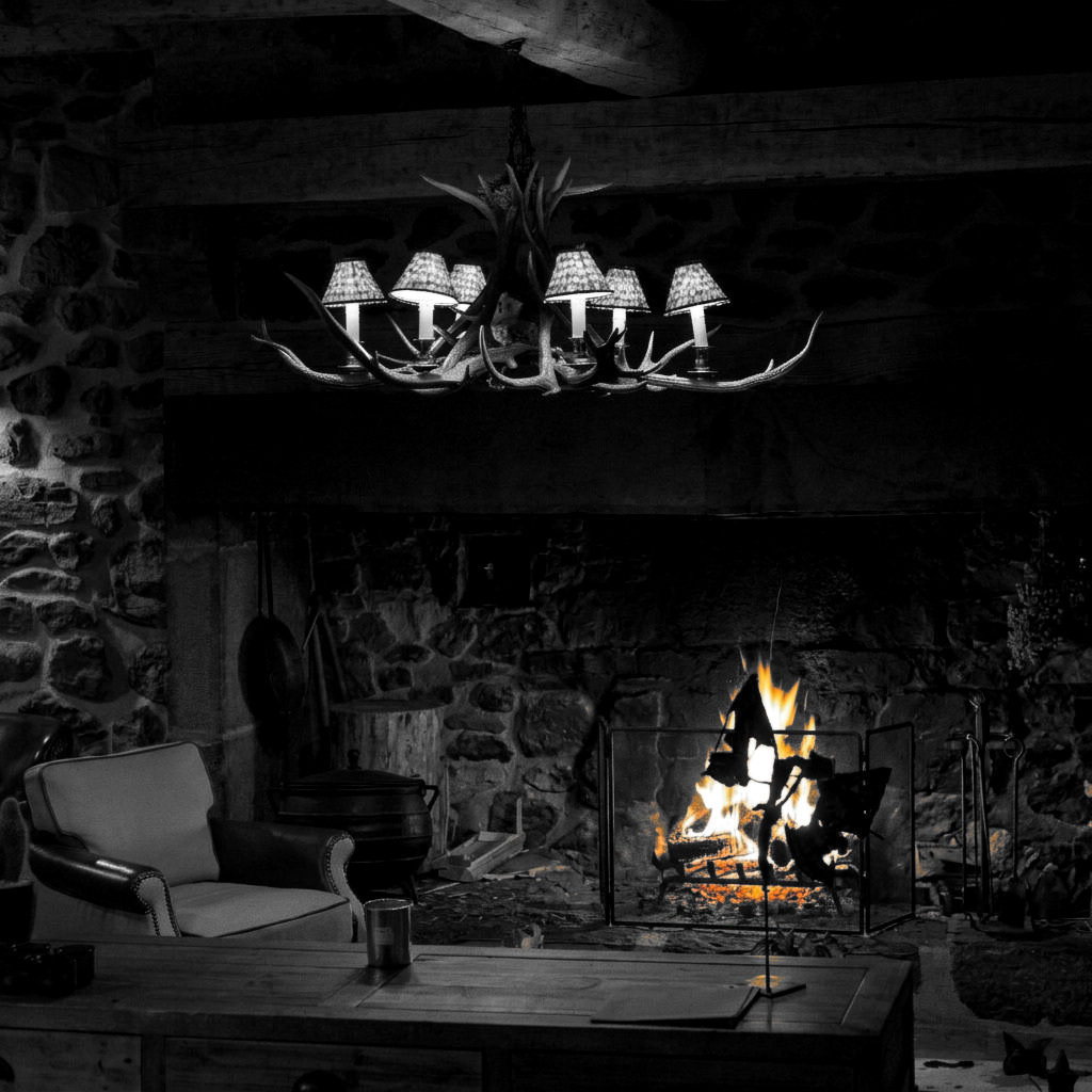 Le feu dans la cheminée du cantou, les flammes seules en couleur dans une pièce en noir et blanc.