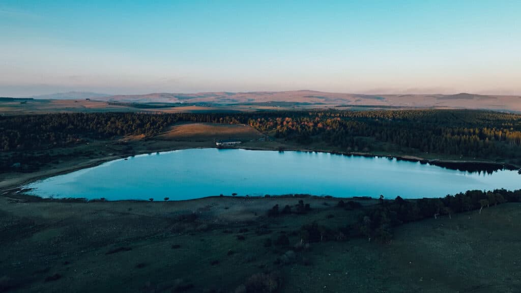 A panoramic view of Lac du Pêcher in Auvergne at sunrise, capturing the luxury of emptiness.