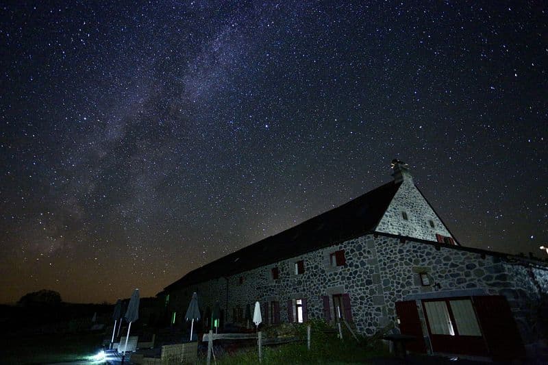 Historic lava-stone building of instants d'Absolu ecolodge facing Lac du Pêcher.