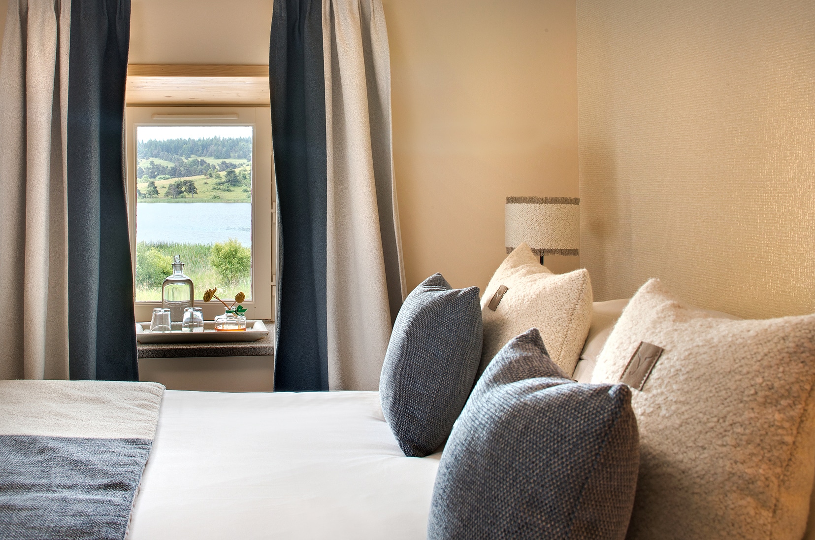 A minimalist suite interior with views of nature, bio-based design, and soft lighting.