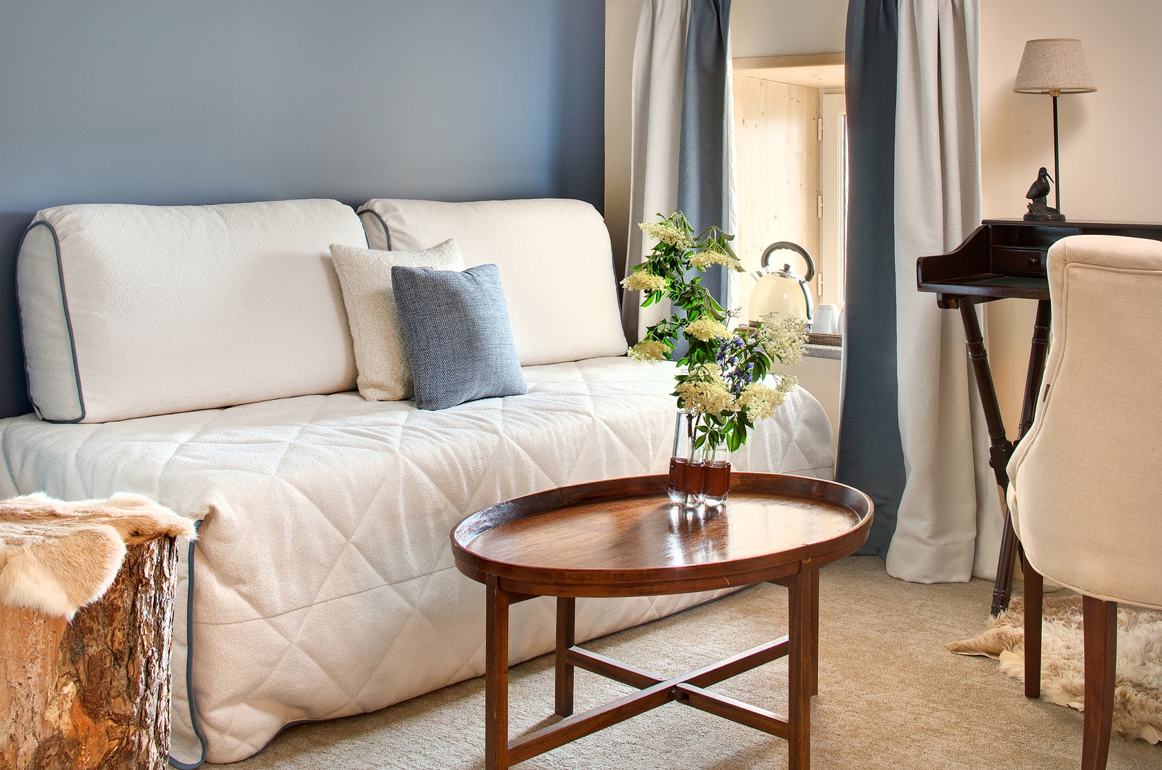 Intérieur épuré d'une suite avec vue sur la nature, design bio-sourcé et lumière douce.