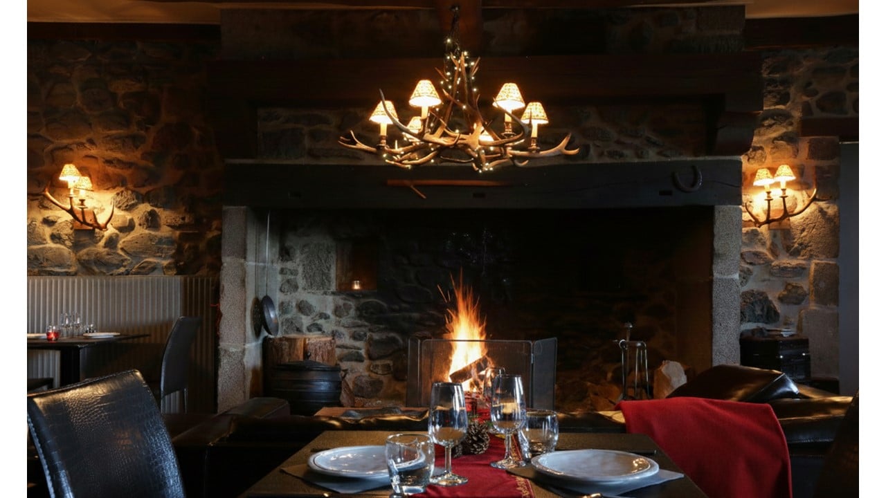Table de Noël dressée pour deux devant le Cantou de l'écolodge instants d'Absolu. Ambiance chaleureuse et romantique.